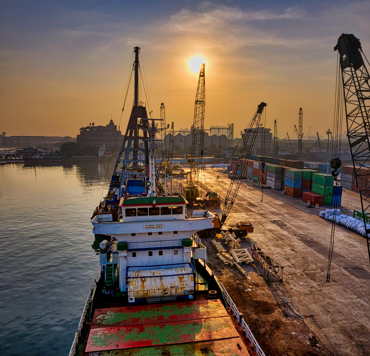 services-01 A vibrant scene of cargo operations during sunrise at a busy port in Indonesia.